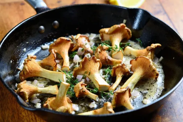 Golden chanterelle mushrooms with butter, shallot, and thyme in a cast-iron skillet