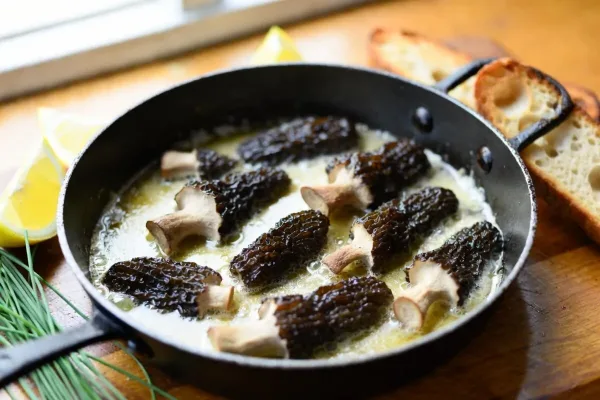 Butter-seared morel mushrooms with lemon in a cast-iron skillet