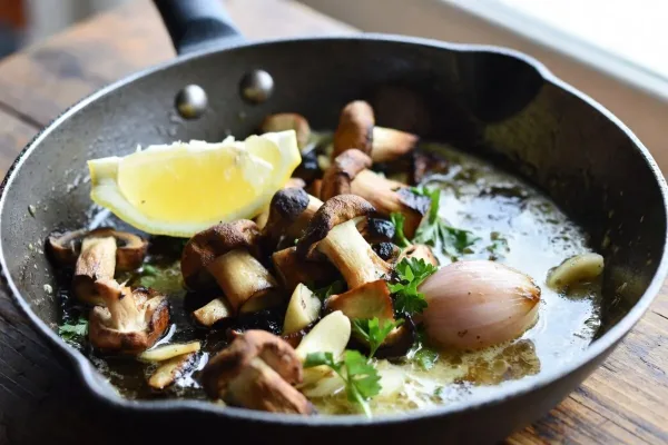 Garlic-butter porcini mushrooms with parsley and lemon in a skillet